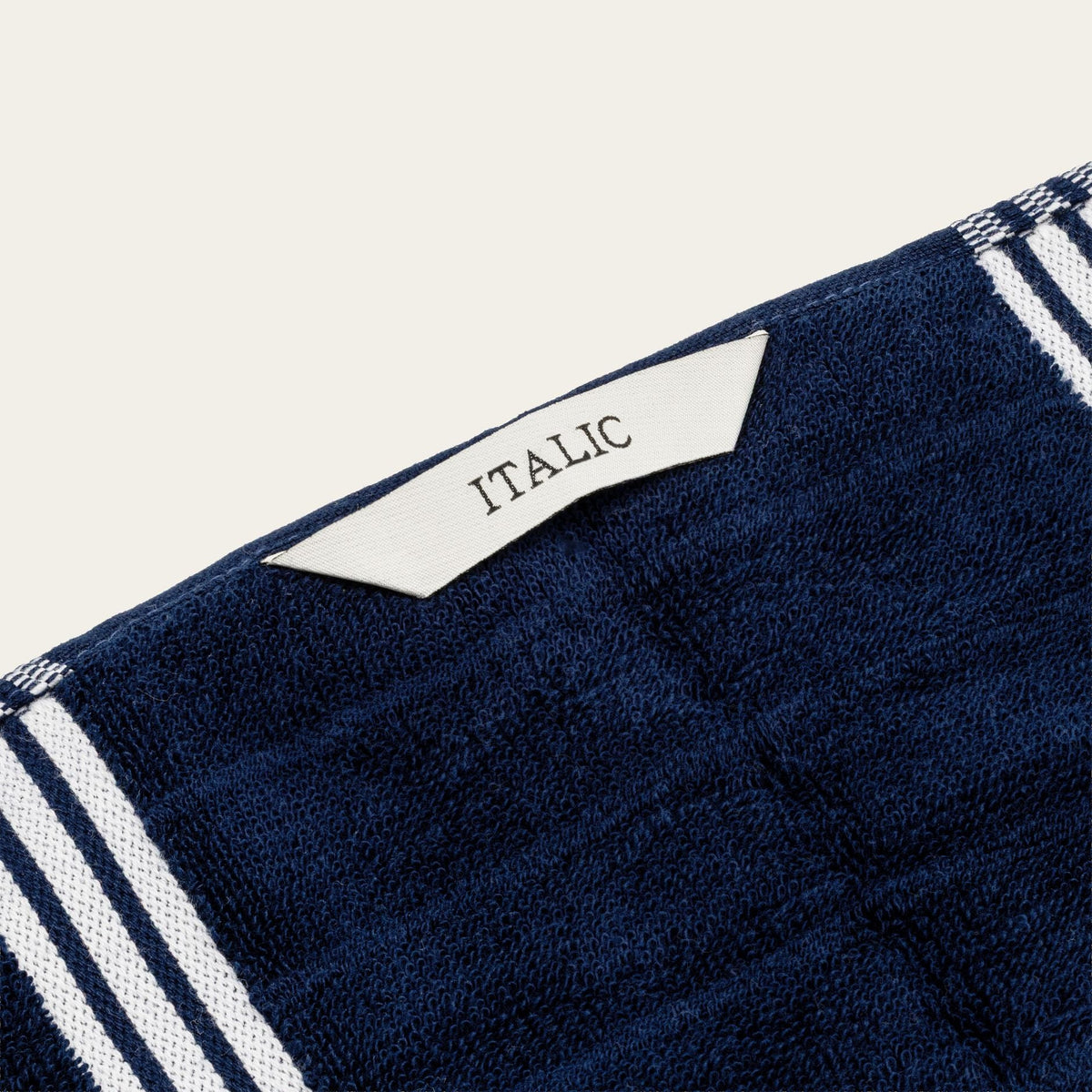 Nautilus navy cotton towel corner with 'ITALIC' label and white stripe borders