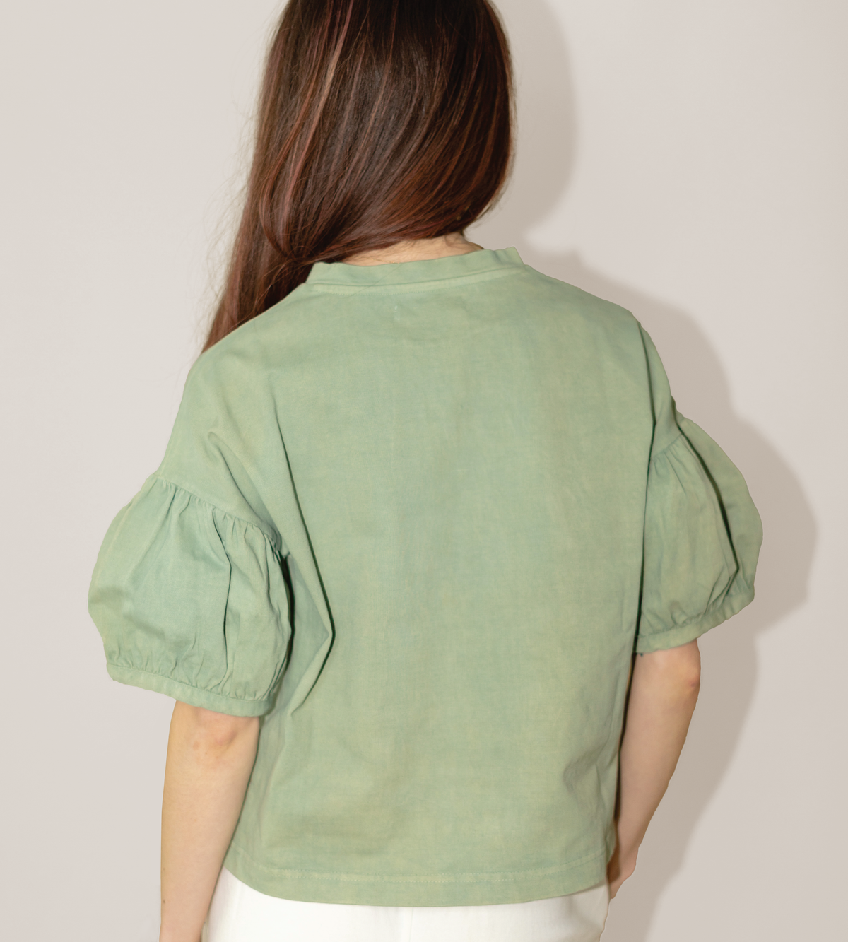Back view of a sage green tee with a straight hem and gathered puff sleeves