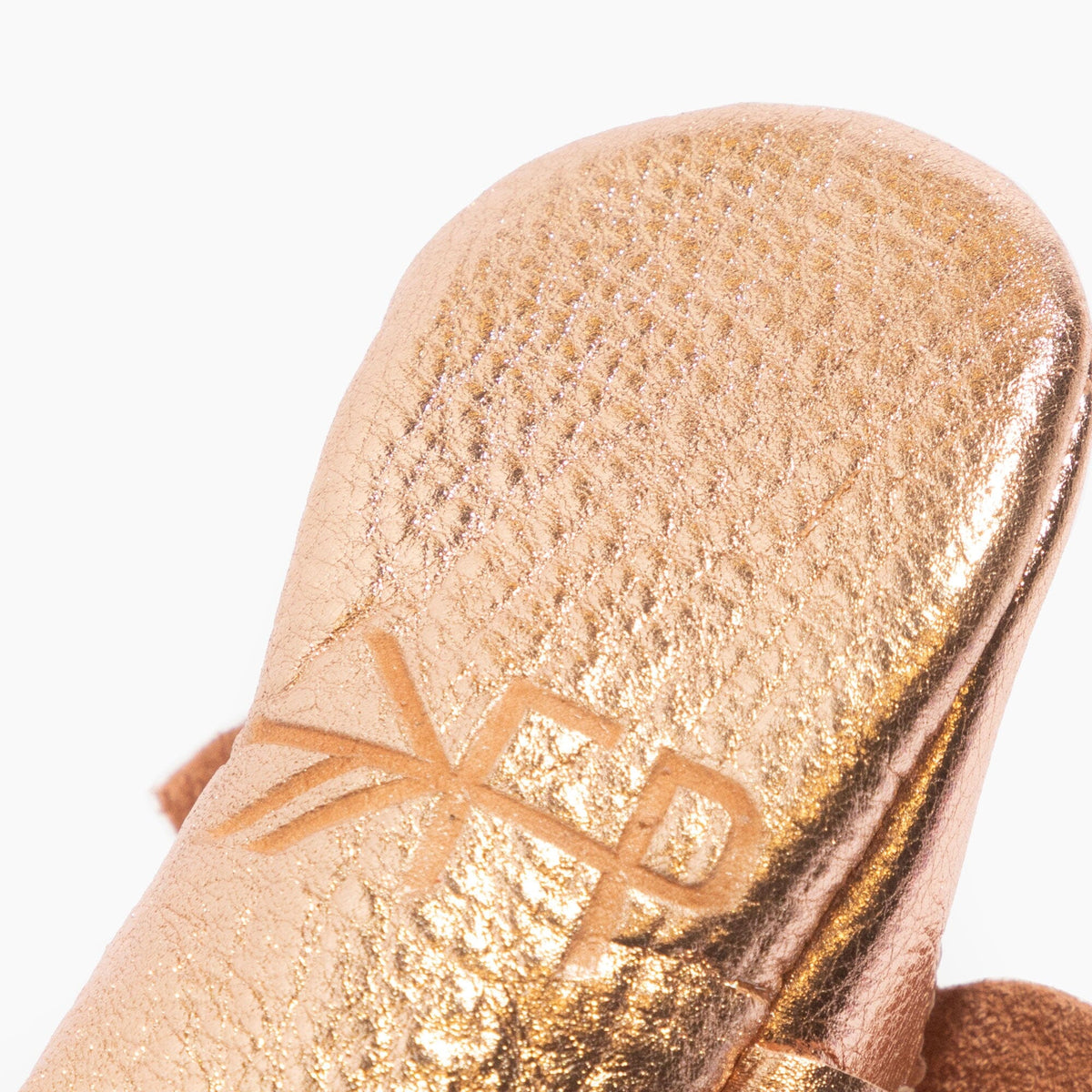 Rose gold baby shoe close-up of glittery fabric and stitched bow detail
