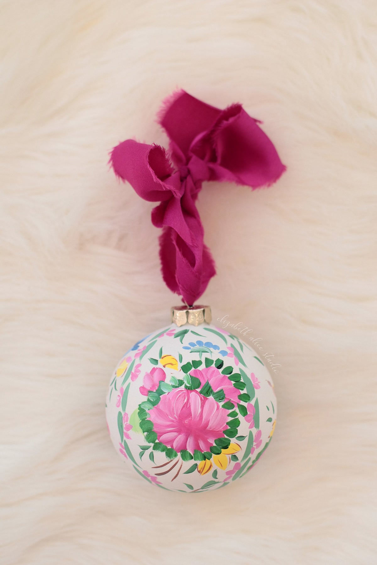 Round hand-painted ornament with a pink rose medallion and magenta bow