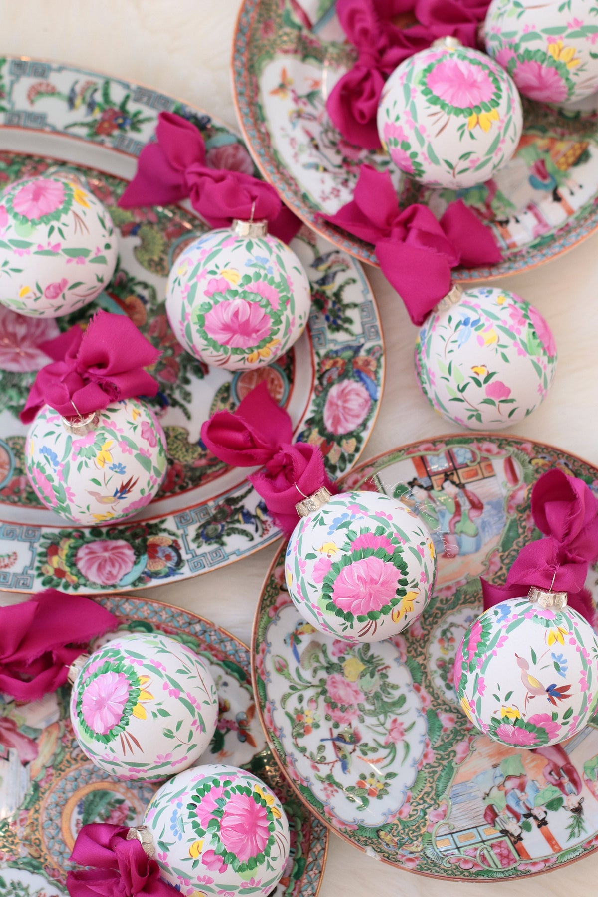 Hand-painted floral ornaments with magenta bows, shown among patterned plates