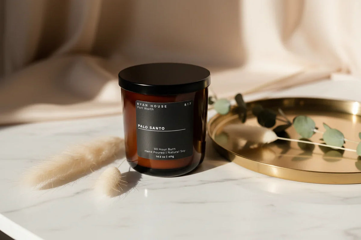 Scented candle in glass jar with black lid, Palo Santo label