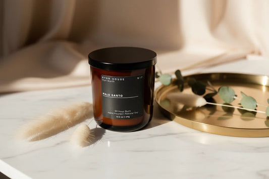 Scented candle in glass jar with black lid, Palo Santo label