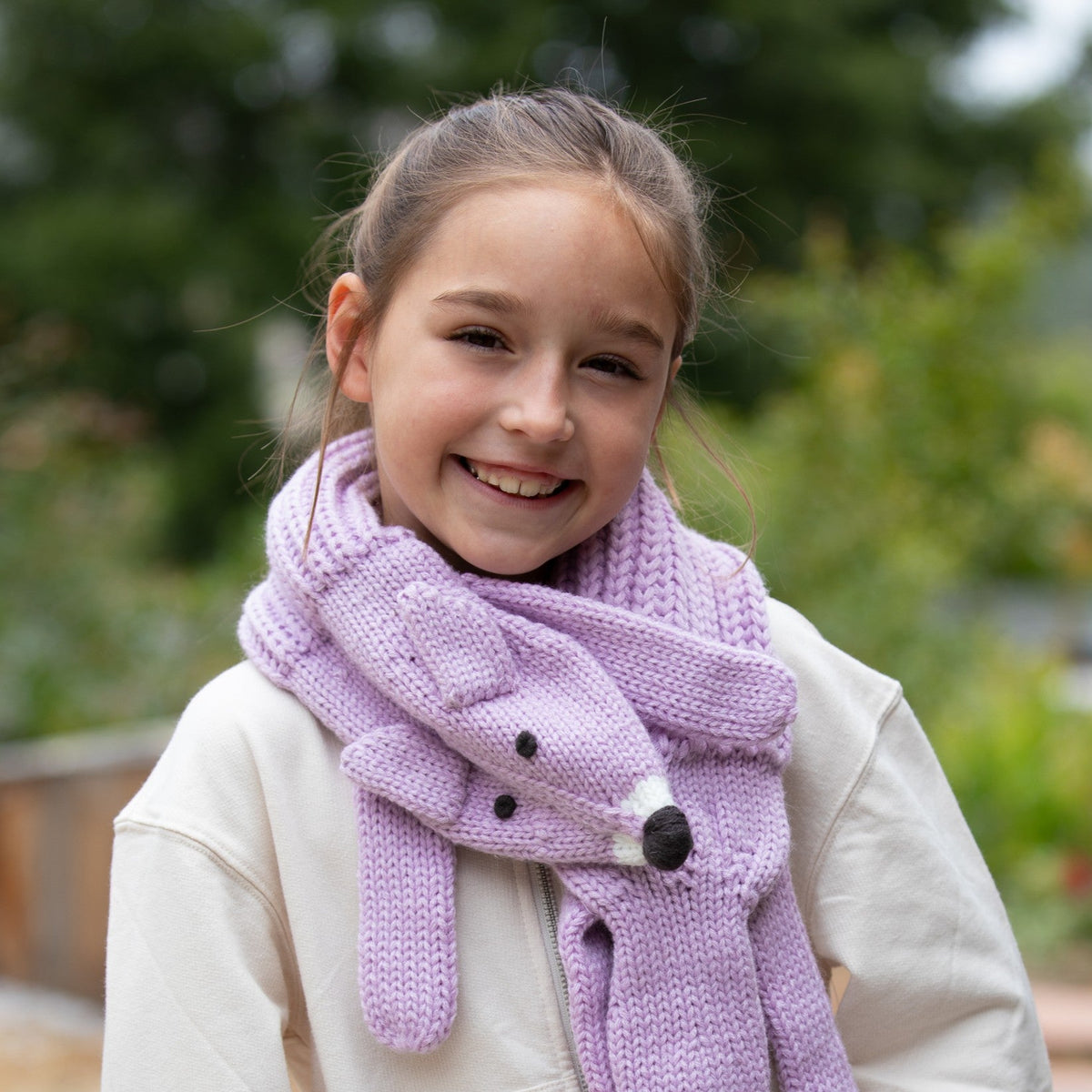 Light purple knit fox scarf worn around a child's neck, with dangling ends and fox face