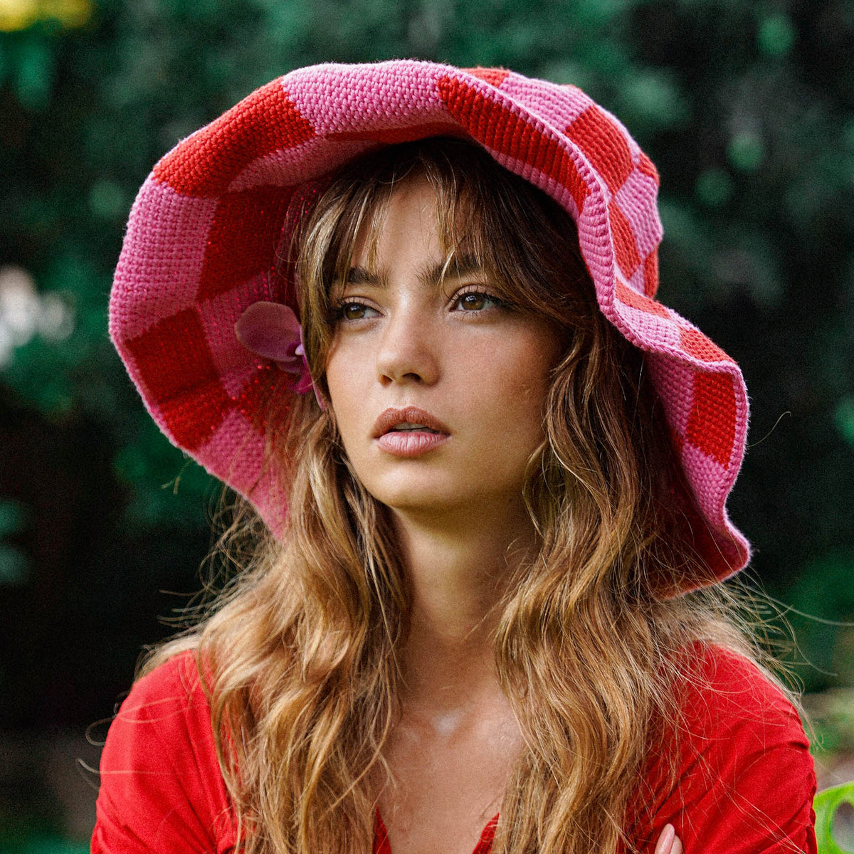 Red and pink checkered crochet sun hat with wide brim and fabric flower at side