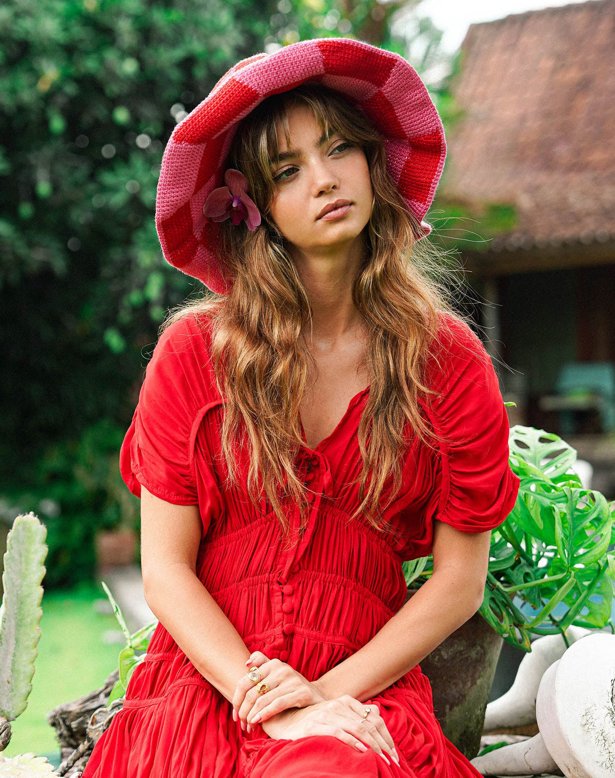 Red and pink checkered crochet bucket hat with wide brim and side flower