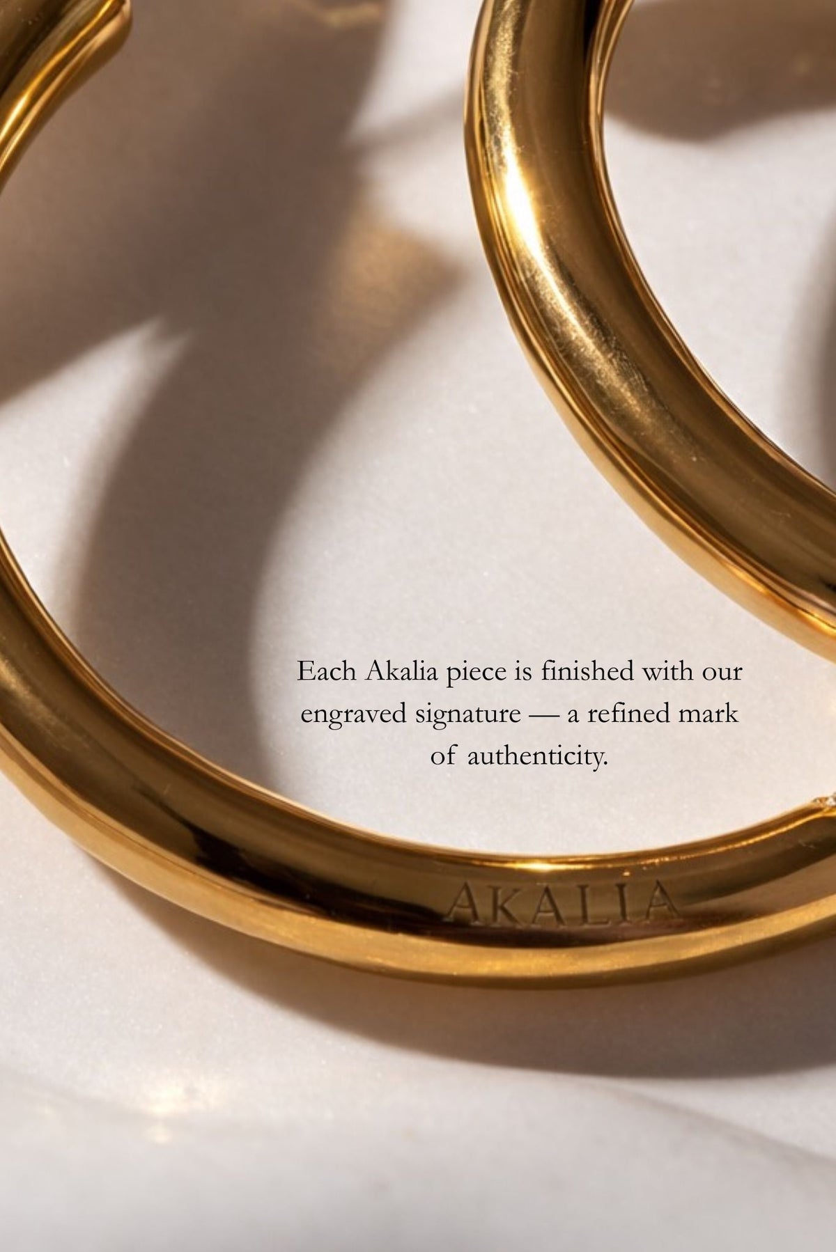 Gold-tone huggie hoop inner curve with engraved signature detail