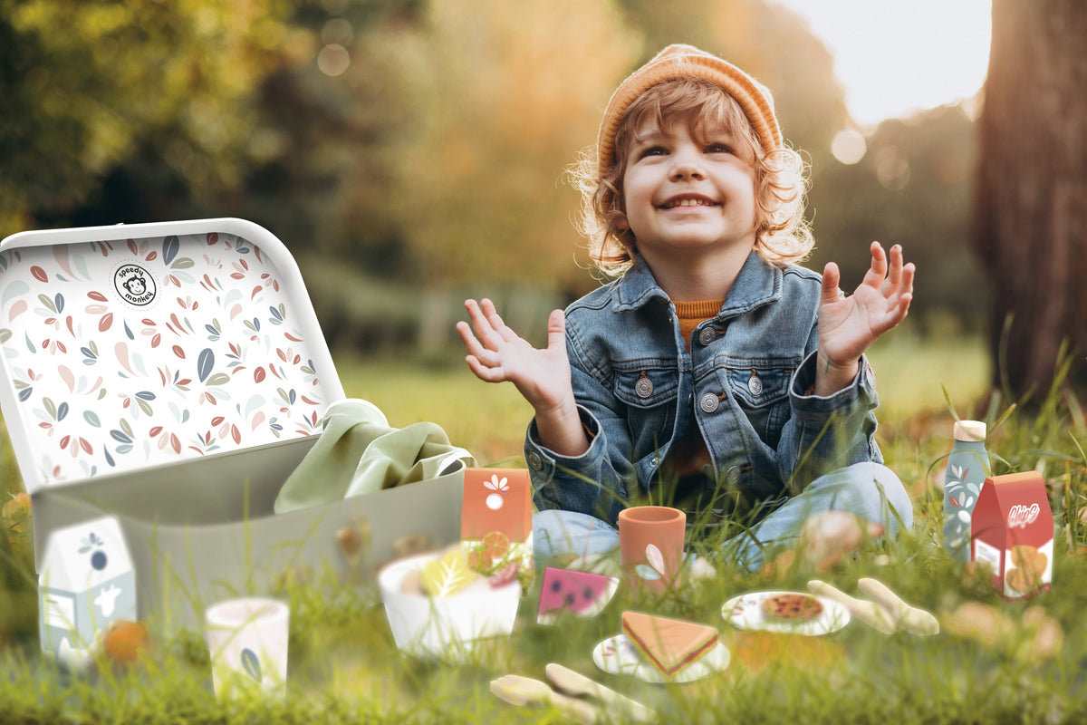 Open children's picnic basket set with toy food, cups, bottle, plates and utensils