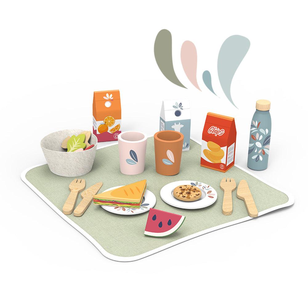 Children's picnic set with cups, bottle, toy food, plates and utensils on a green mat