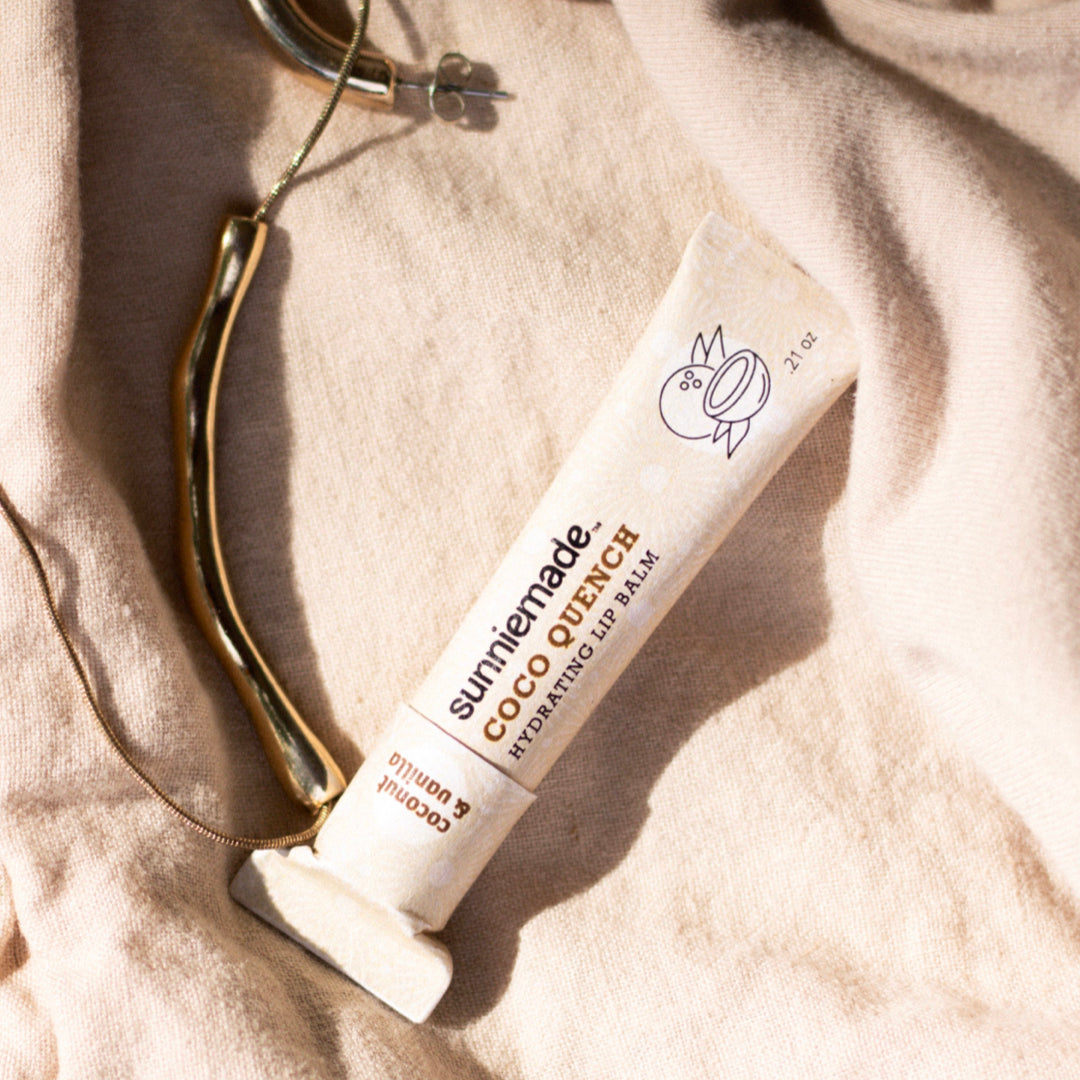 Hydrating lip balm tube, white with Coco Quench branding and orange text