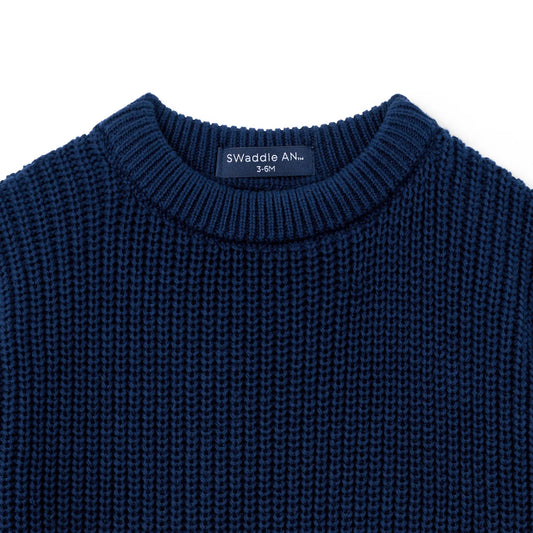 Navy chunky-knit baby romper neckline close-up with textured knit detail