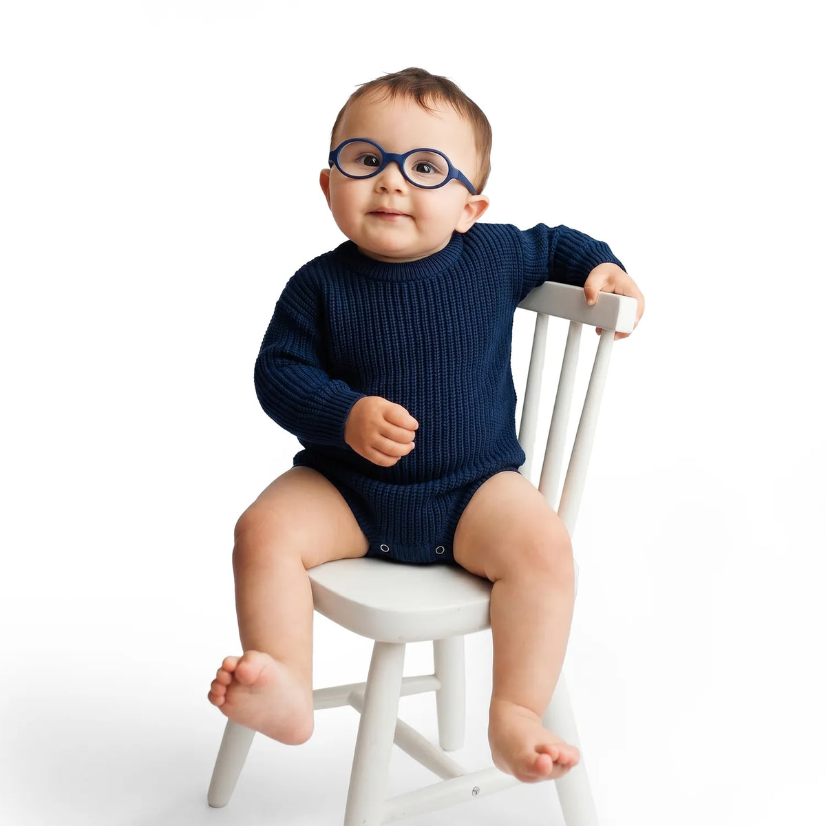 Navy chunky-knit baby romper on baby, long sleeves and snap leg closure