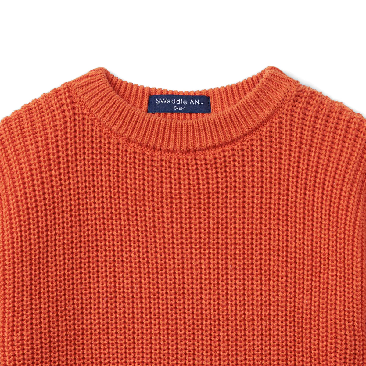 Orange rust chunky knit baby romper crew neckline with brand tag on the collar