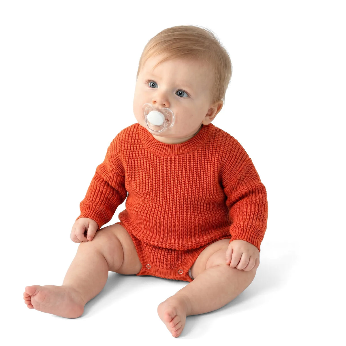 Baby wearing orange rust chunky knit romper, long sleeves and snap bottom closure