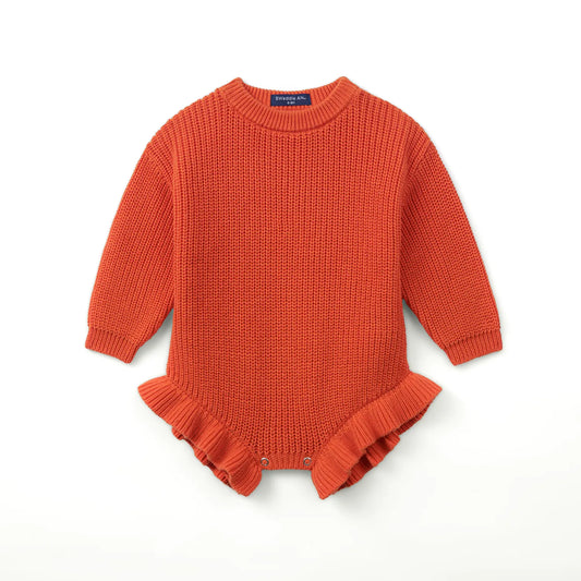 Orange-rust chunky knit baby romper with ruffled hem and ribbed cuffs