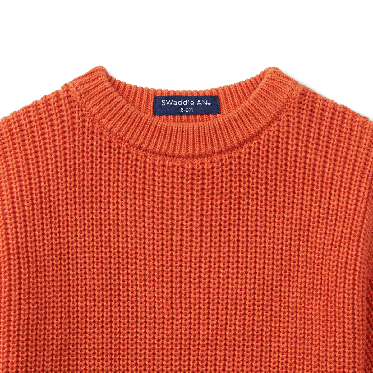 Orange-rust chunky knit romper with crew neckline and brand label at collar