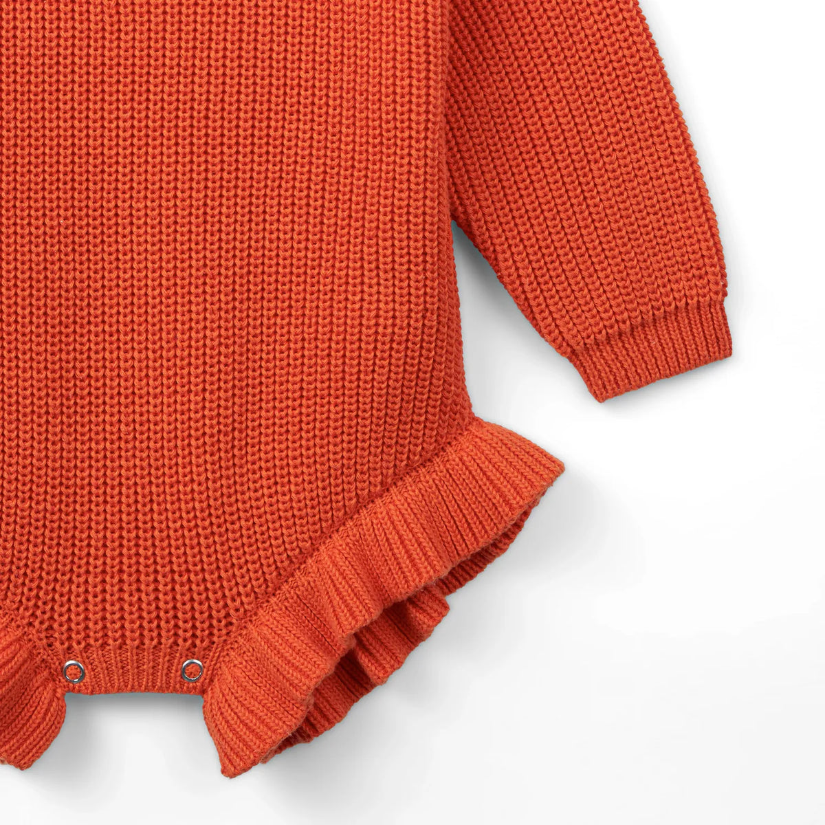 Orange-rust knit romper hem with ruffled trim and snap placket at bottom