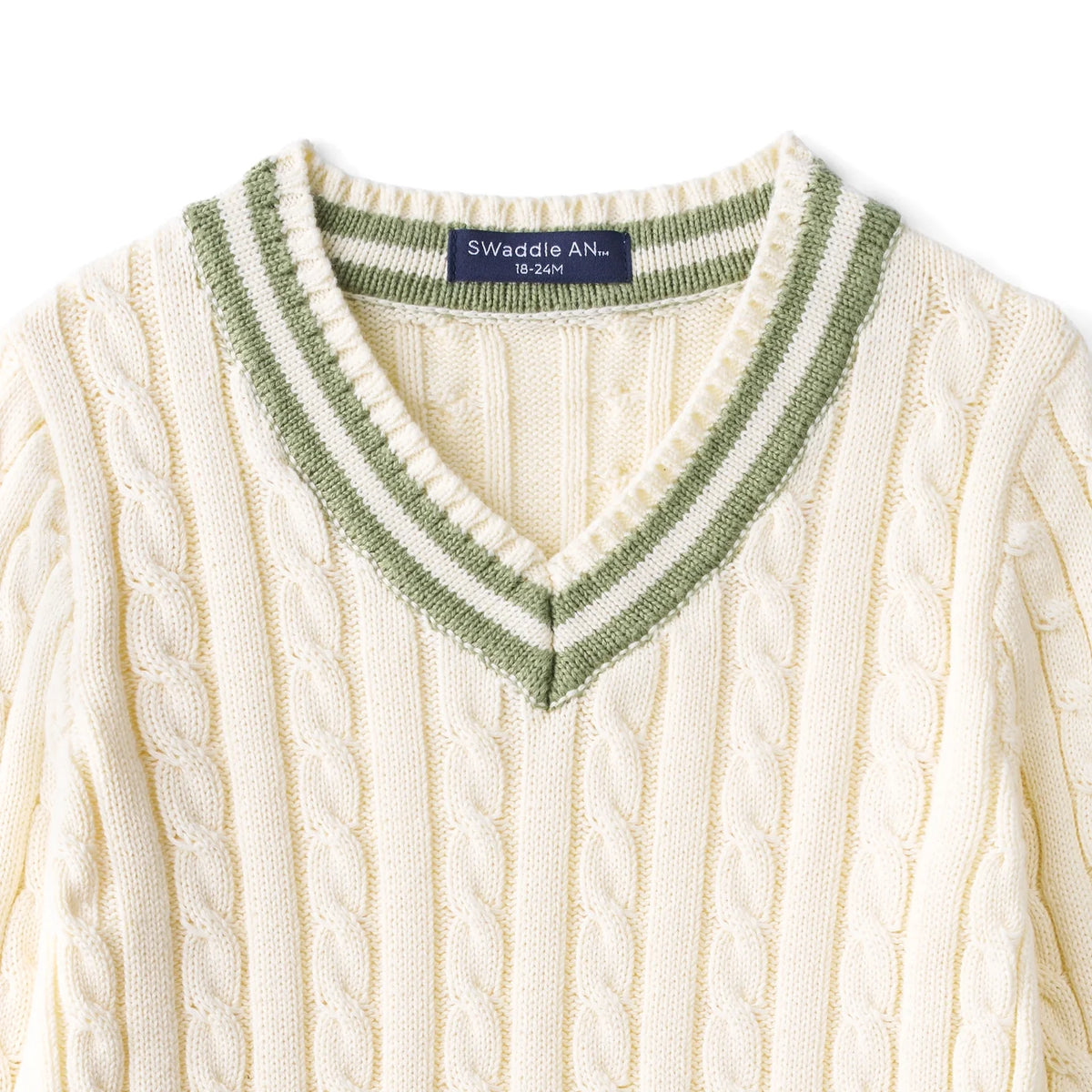 Kids cream cable knit sweater close-up of green V-neck and ribbed collar