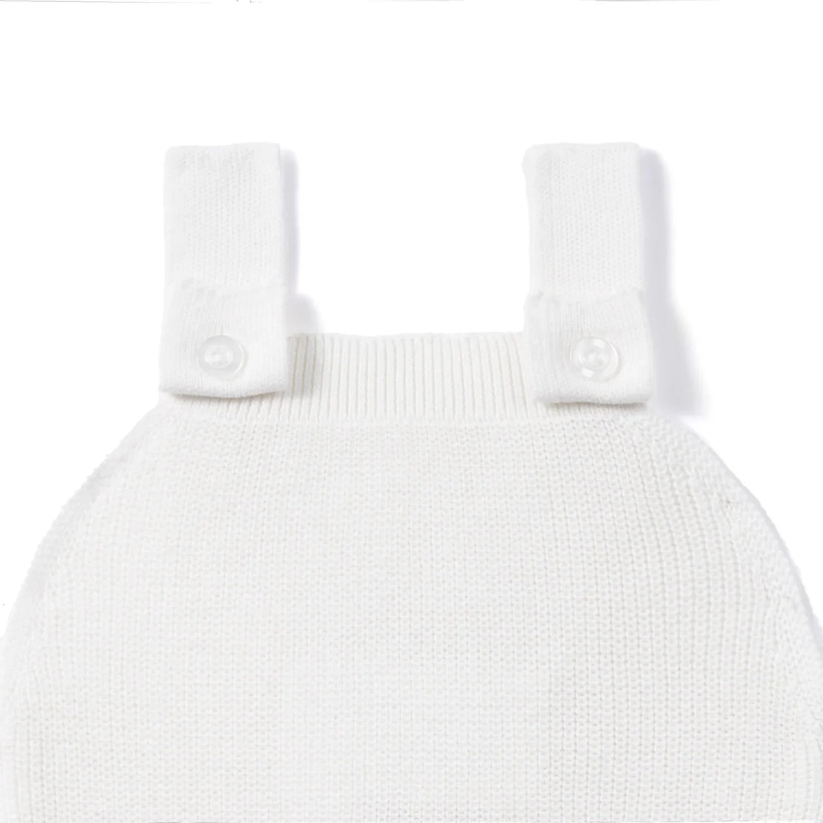 White knit baby romper with button shoulder straps and textured knit bodice.