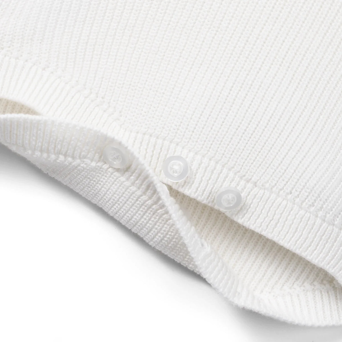 White knit baby romper with button trim and ribbed hem leg openings.