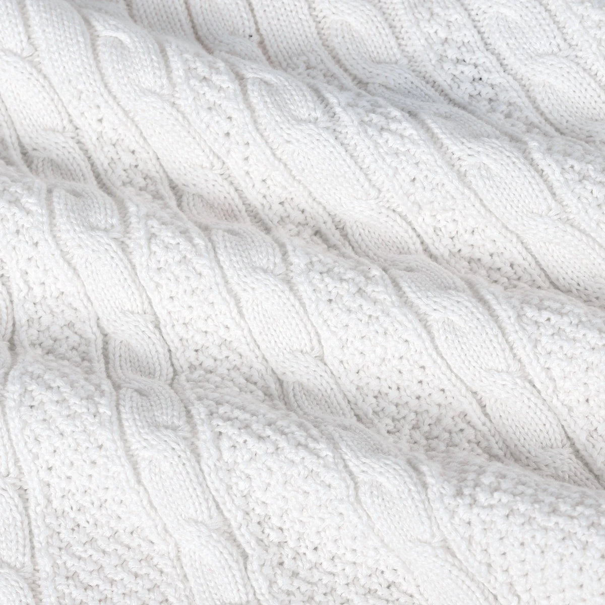 White cable-knit polo dress fabric close-up with raised braided texture.