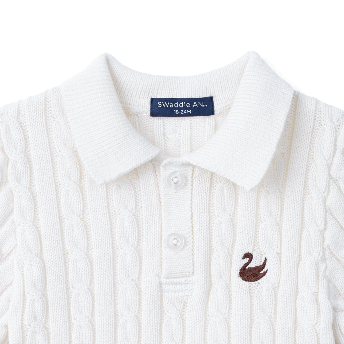 White cable-knit polo sweater close-up of pointed collar and button placket