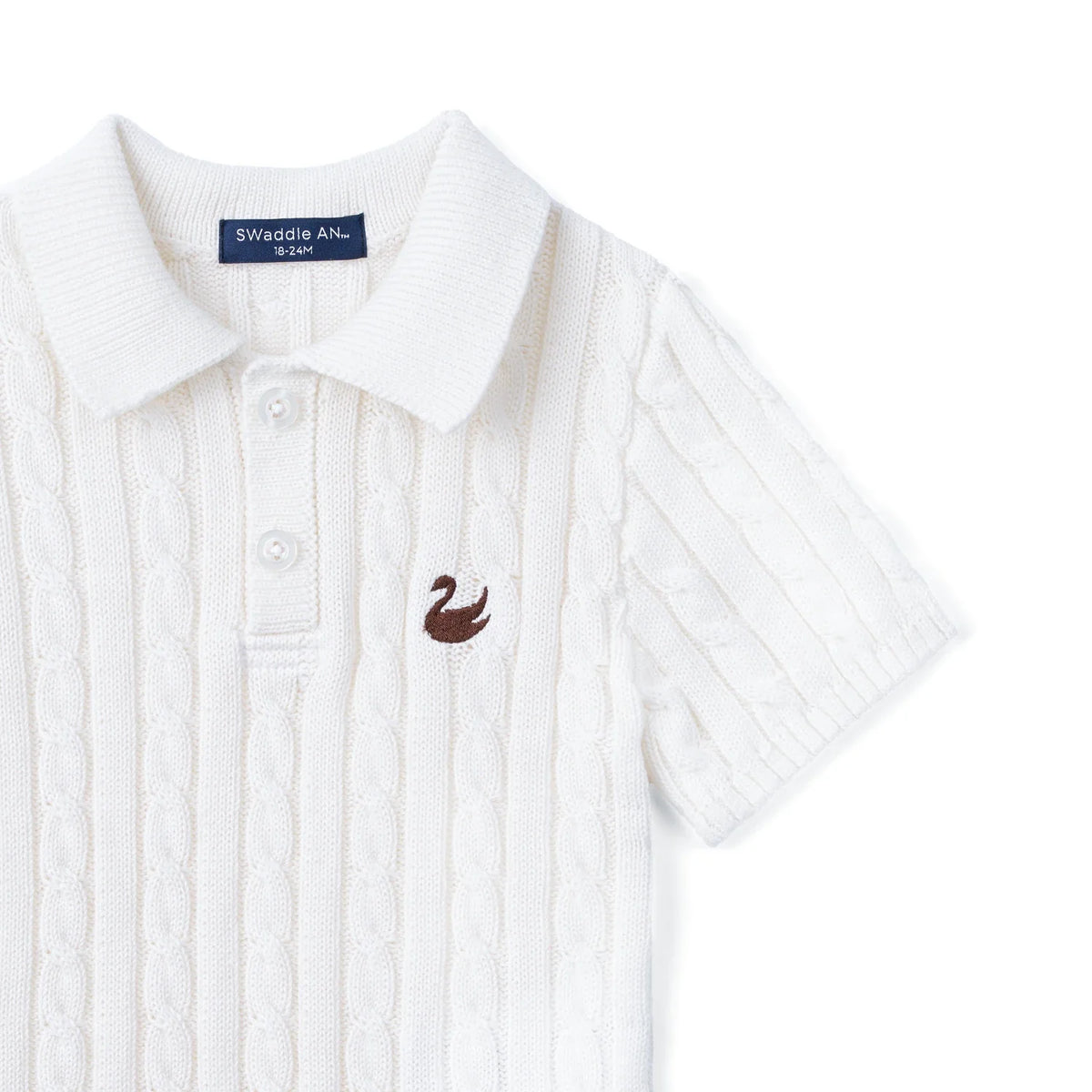 White cable-knit polo sweater close-up with chest logo patch and button placket