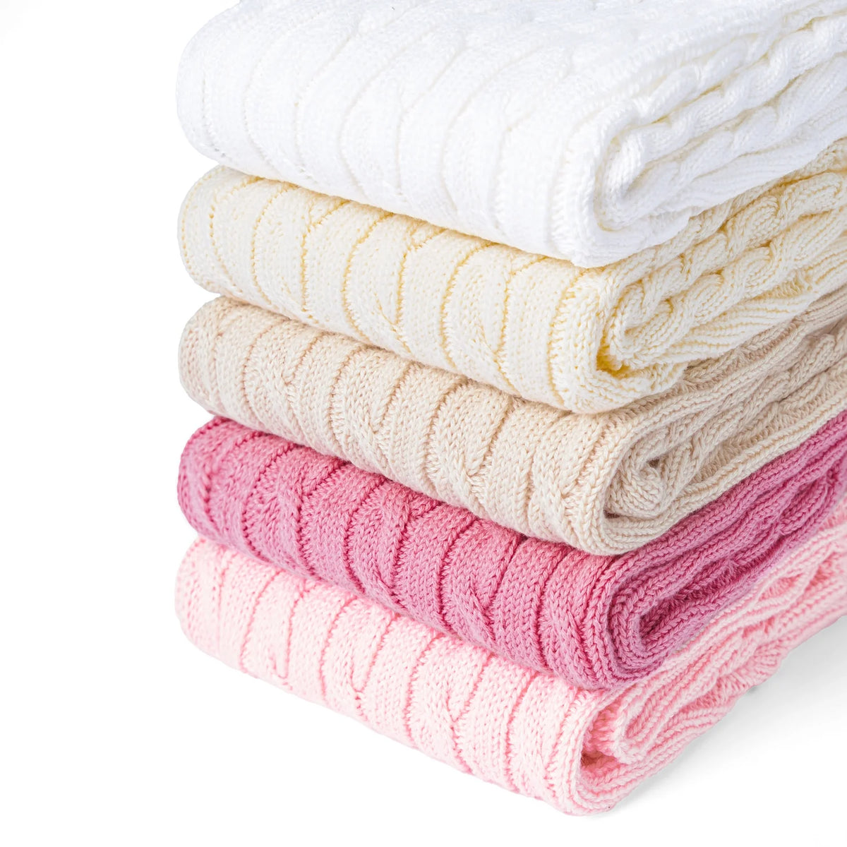 Stack of folded cable-knit shorts in white, cream, and pink tones