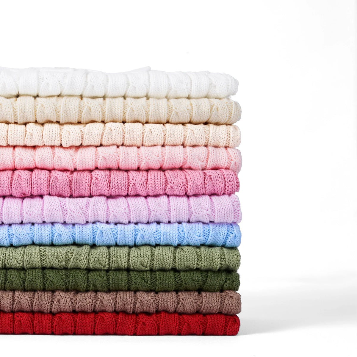 Stack of cable-knit sleeveless polo shirts, including pink folded knit pieces