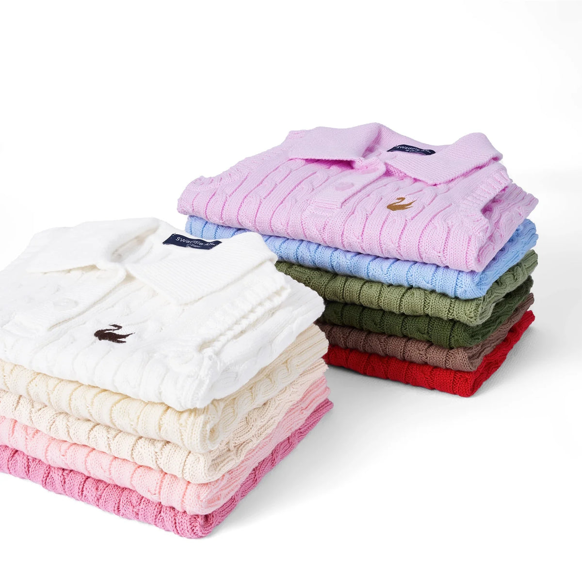 Assorted-color cable-knit sleeveless polo shirts folded in stack