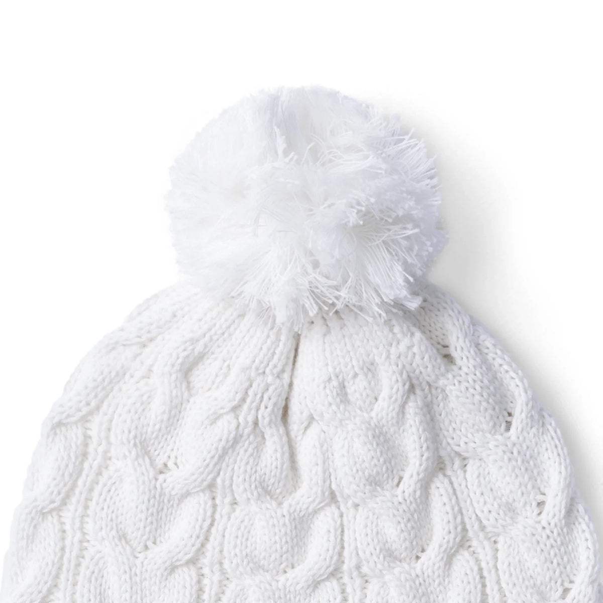 White cable knit beanie with large pom-pom and ribbed brim, texture close-up.