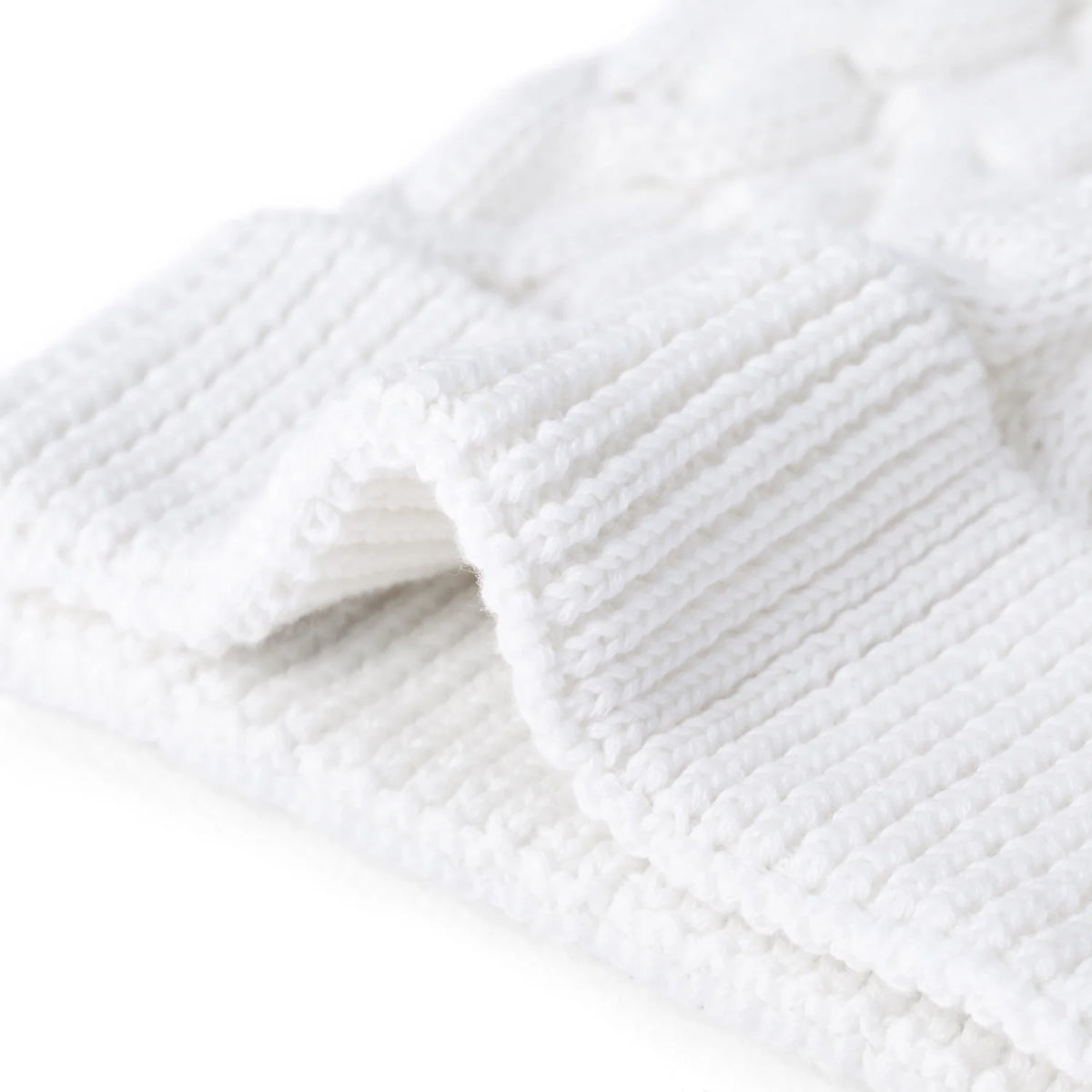 White ribbed beanie cuff with cable knit texture and soft pom-pom detail.