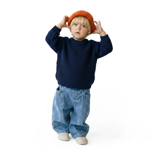 Navy knit baby sweater worn by child, crew neck with ribbed cuffs and hem