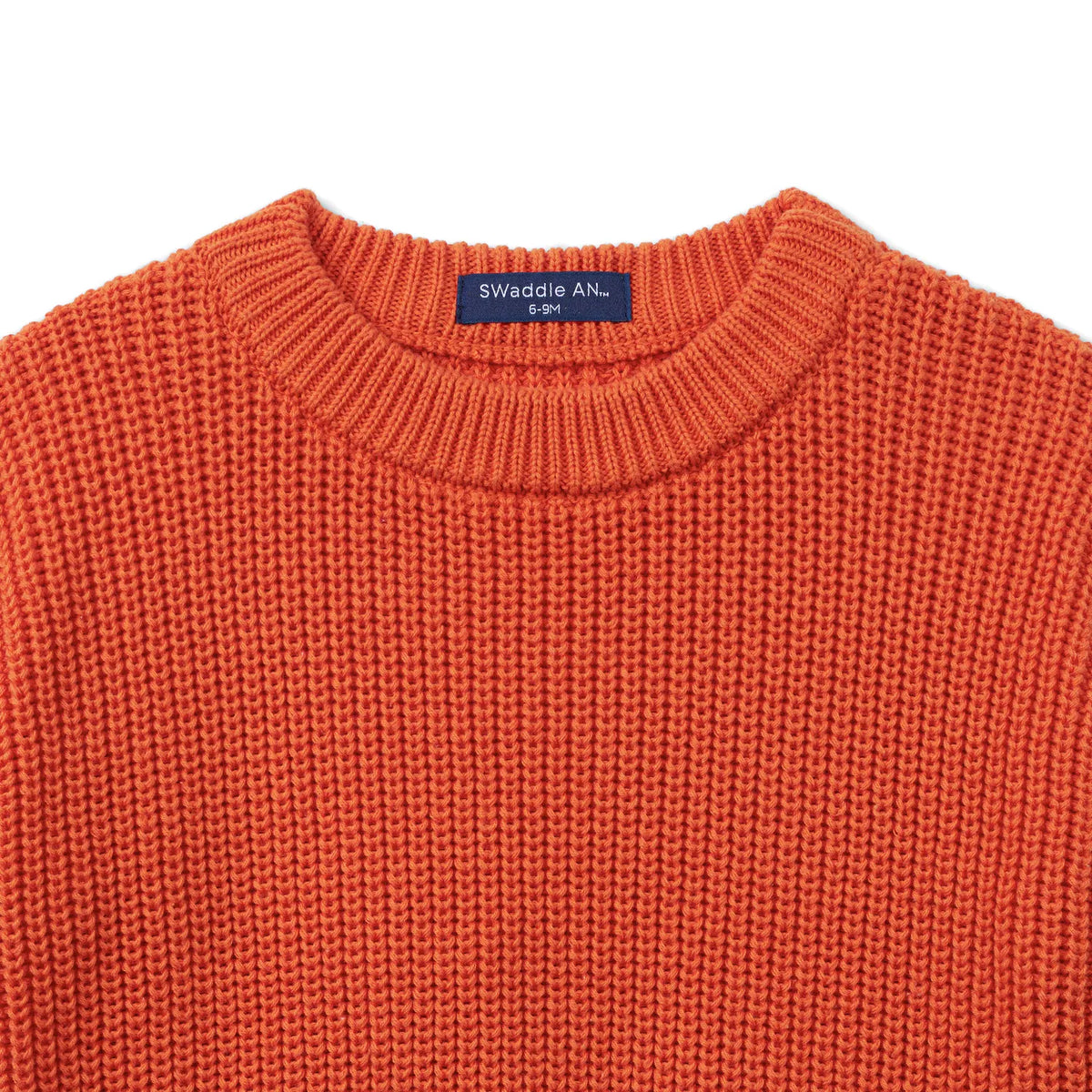 Orange rust knit baby sweater with crew neckline and brand label