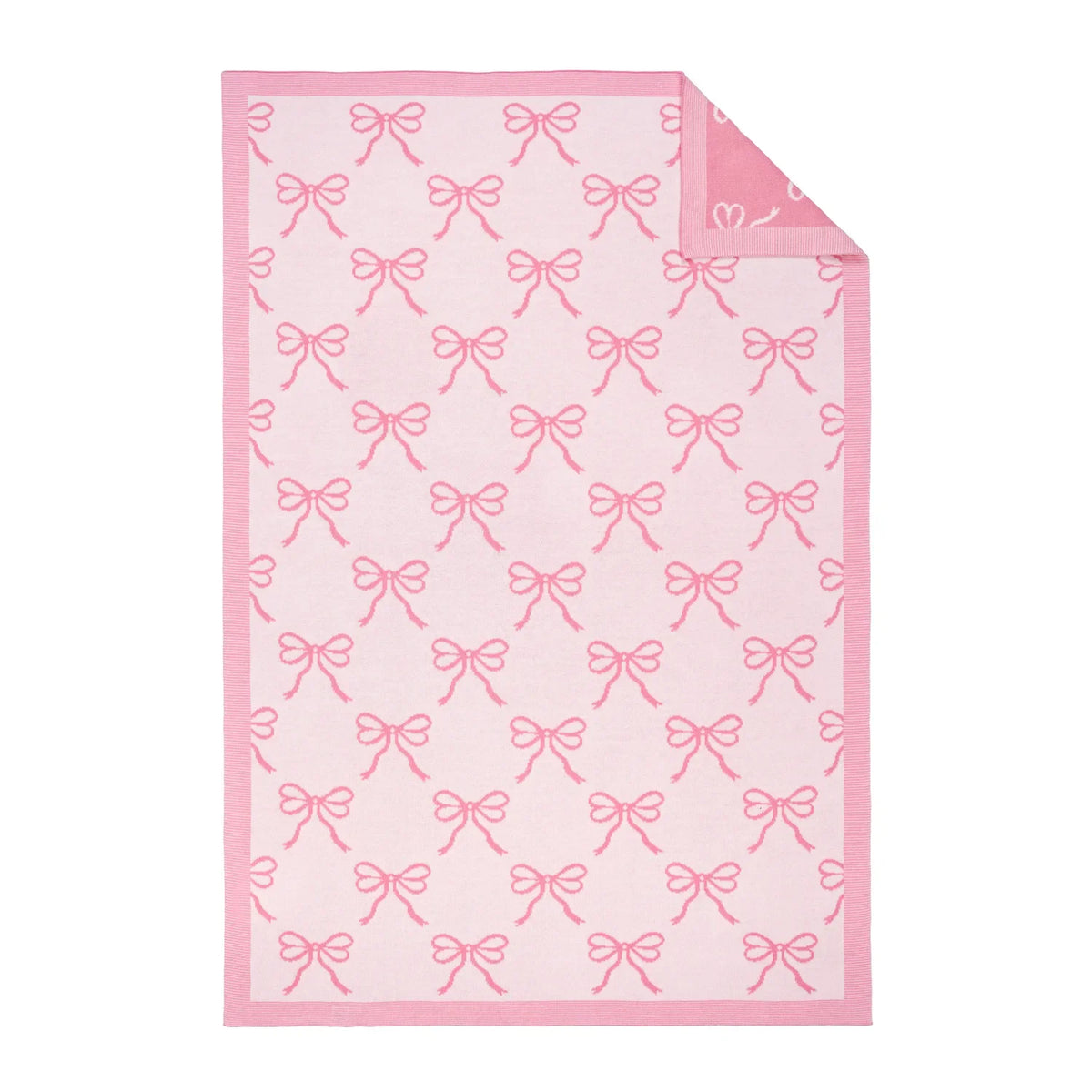 Pink baby blanket with white bow jacquard pattern, corner folded and layered.