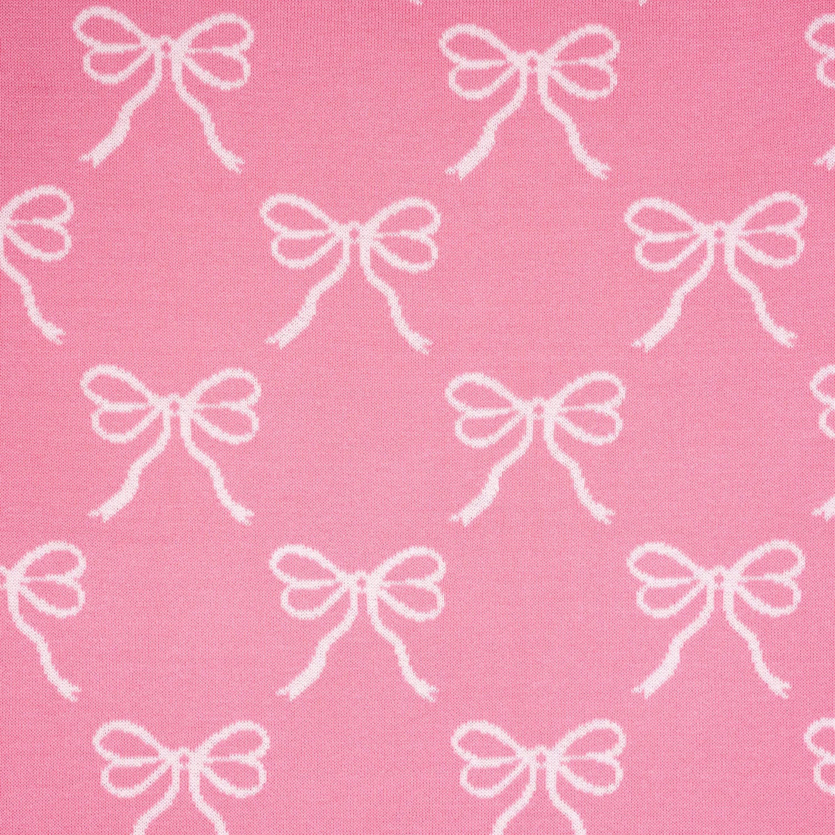 Pink baby blanket with repeating white bow pattern, tight fabric close-up.
