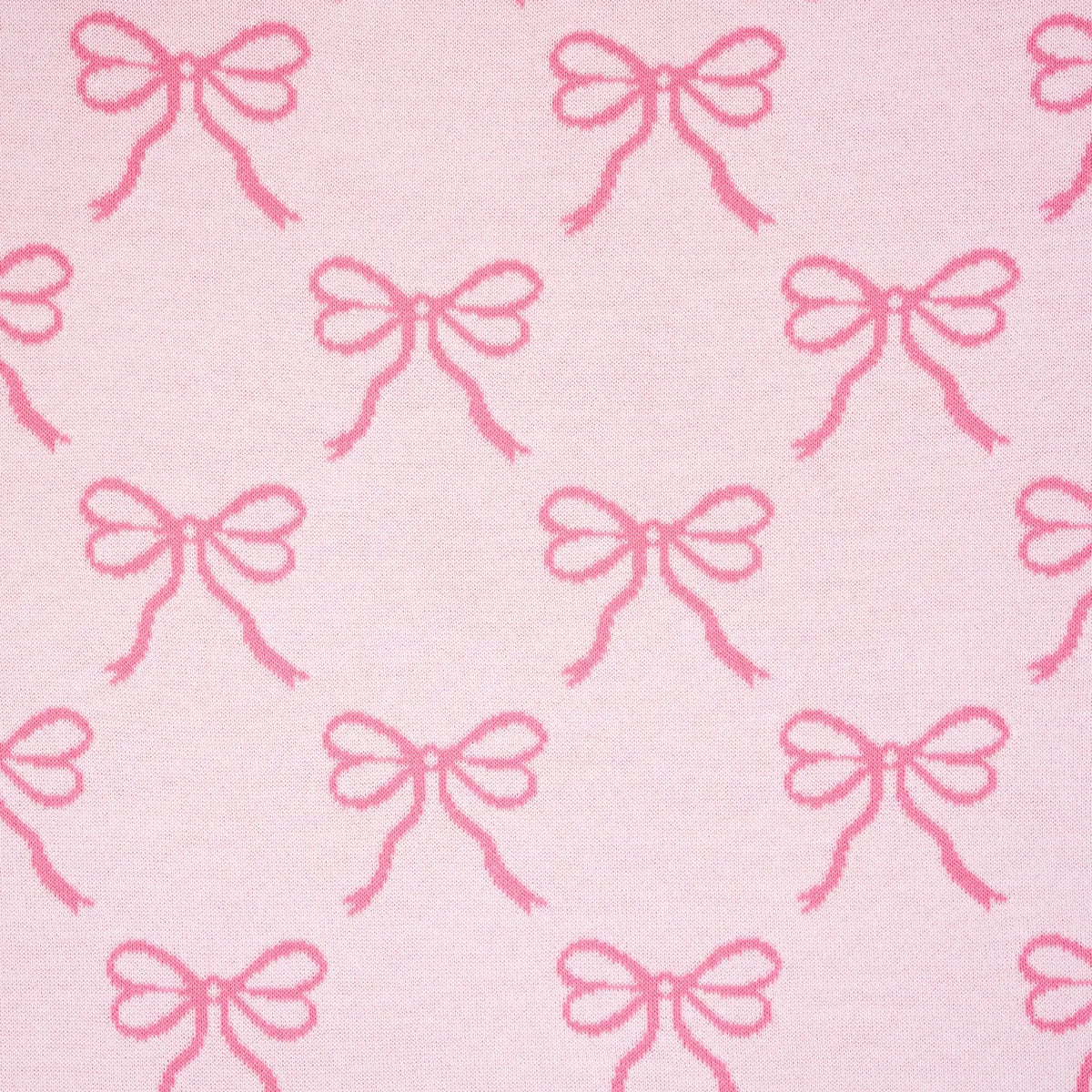Light pink knit baby blanket with repeating pink bow pattern, close-up.