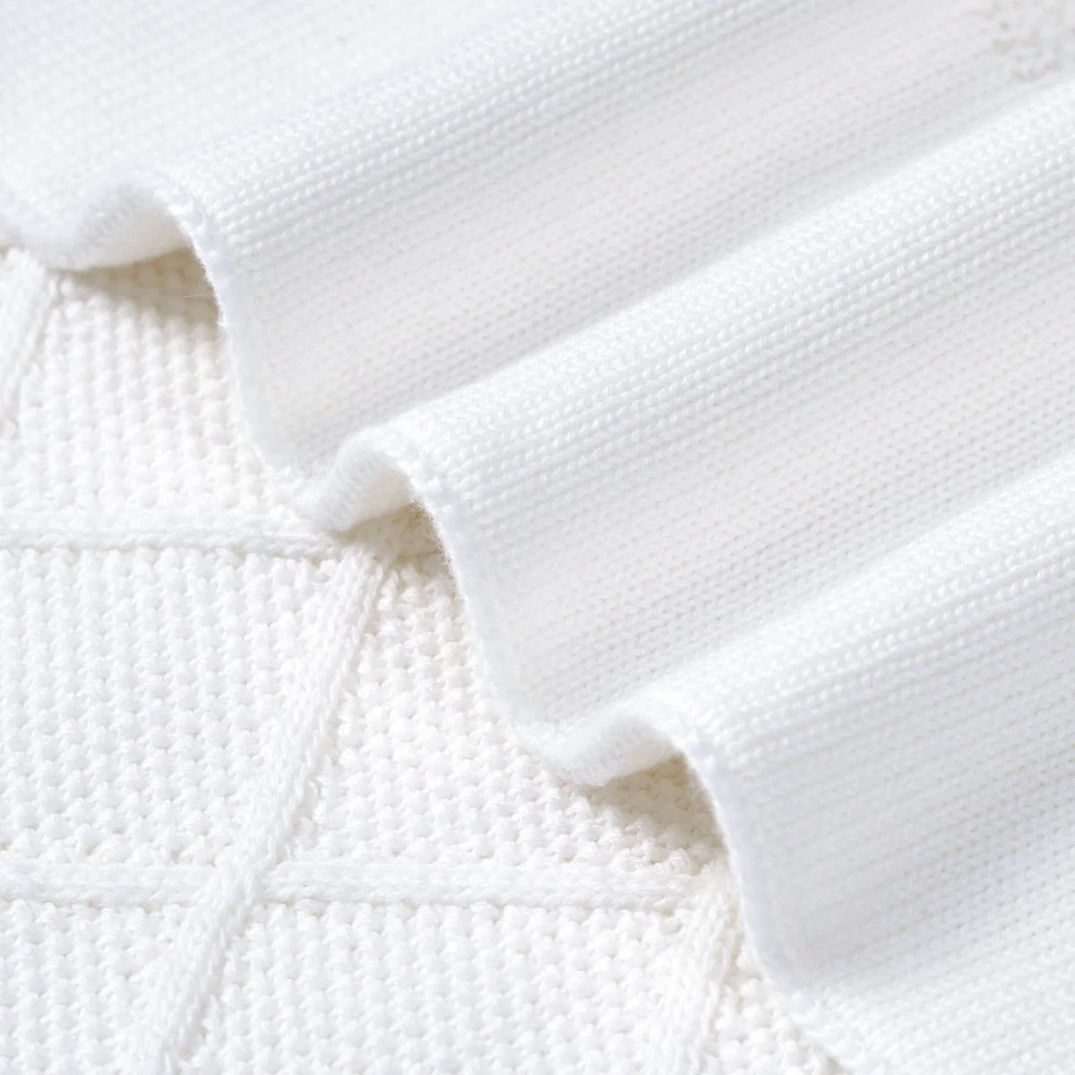 White diamond-stitch baby blanket edge with stitched border and knit texture.