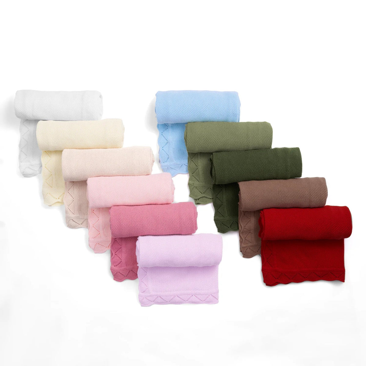 Assorted lace knit baby blankets stacked in cream, pink, blue, green, brown, and red