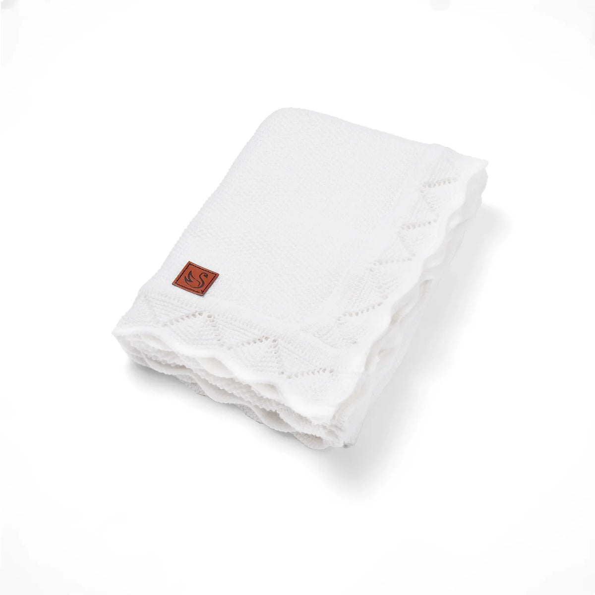 Heirloom lace knit baby blanket, folded white with lace trim and stitched edges