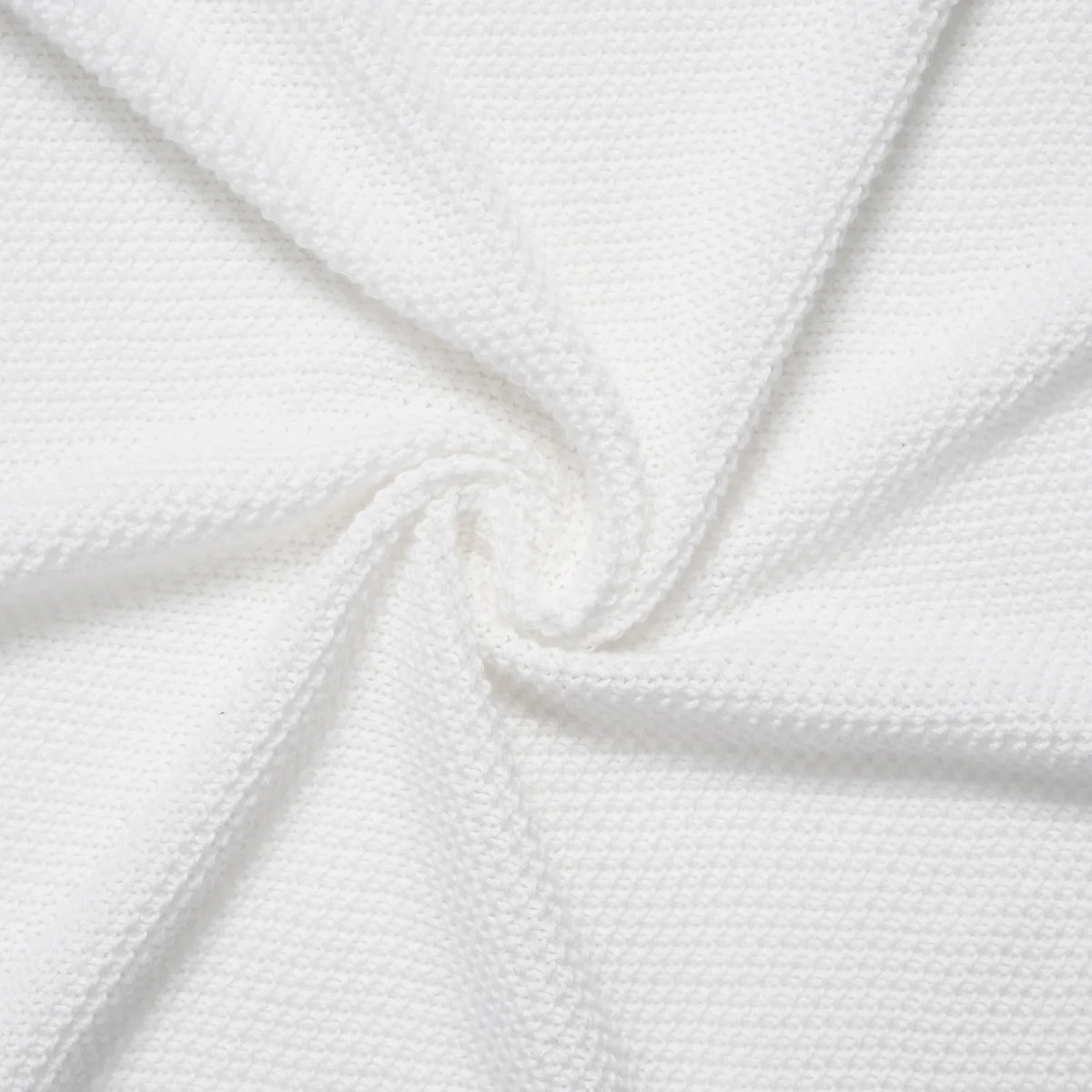 Heirloom lace knit baby blanket, close-up fold with white woven knit texture