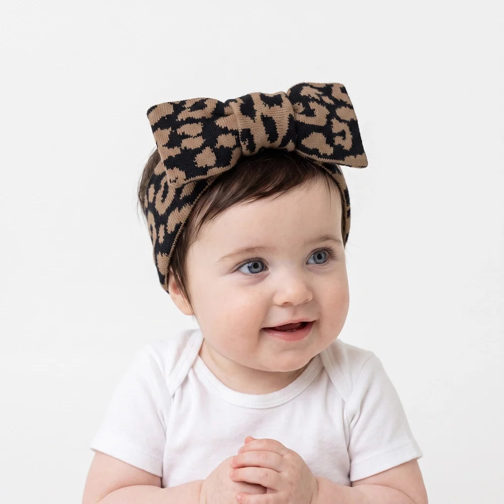 Leopard knitted topknot bow headband on baby with long overhanging bow