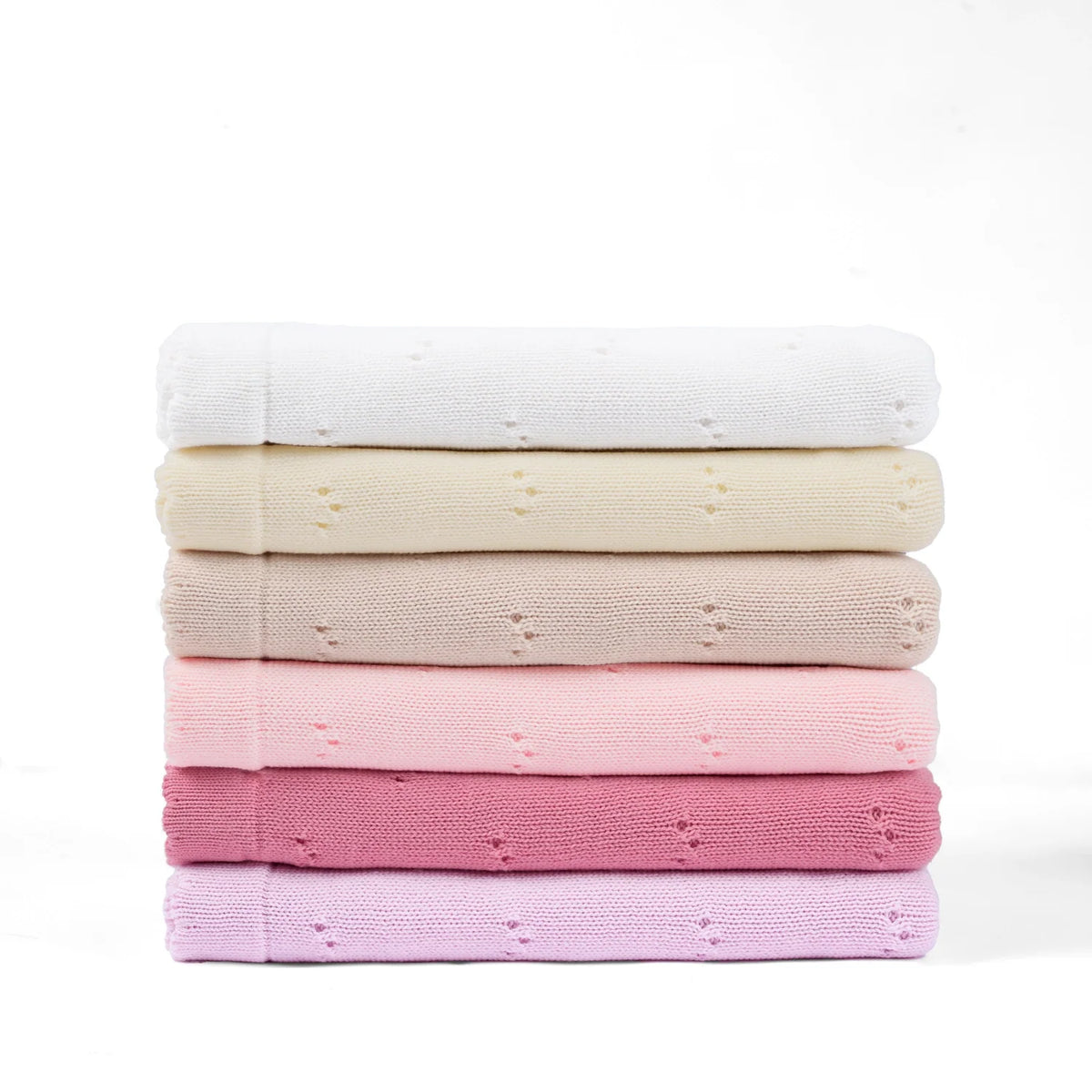 Pointelle knit baby blankets stacked in pastel shades, including white, pink, and purple