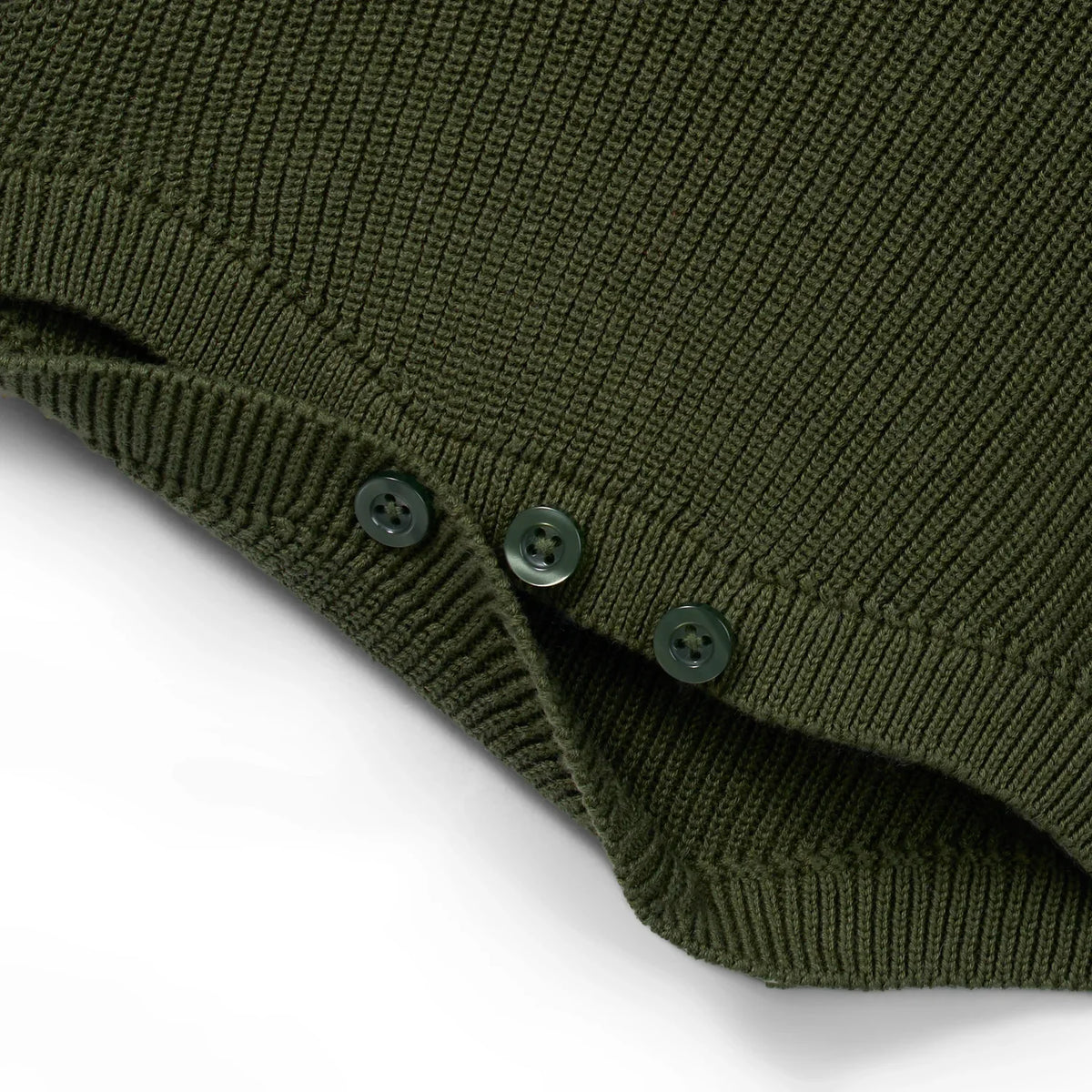 Forest green knit romper showing strap seam and three button details