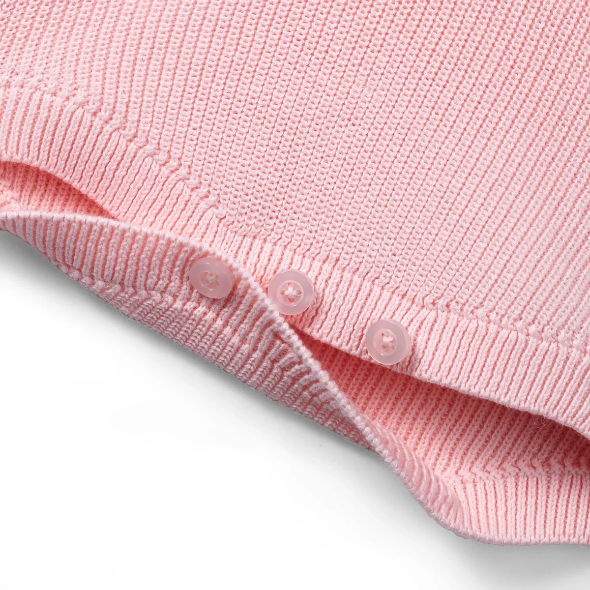 Pink knit romper hem with ribbed trim and snap buttons