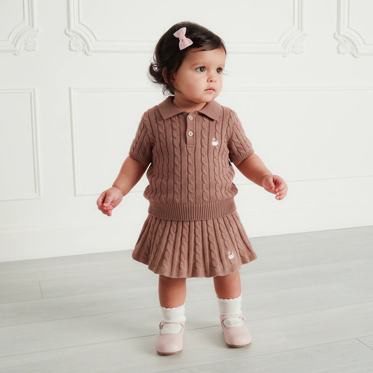 Toddler wearing mocha cable-knit polo sweater with short sleeves, ribbed collar, button placket.