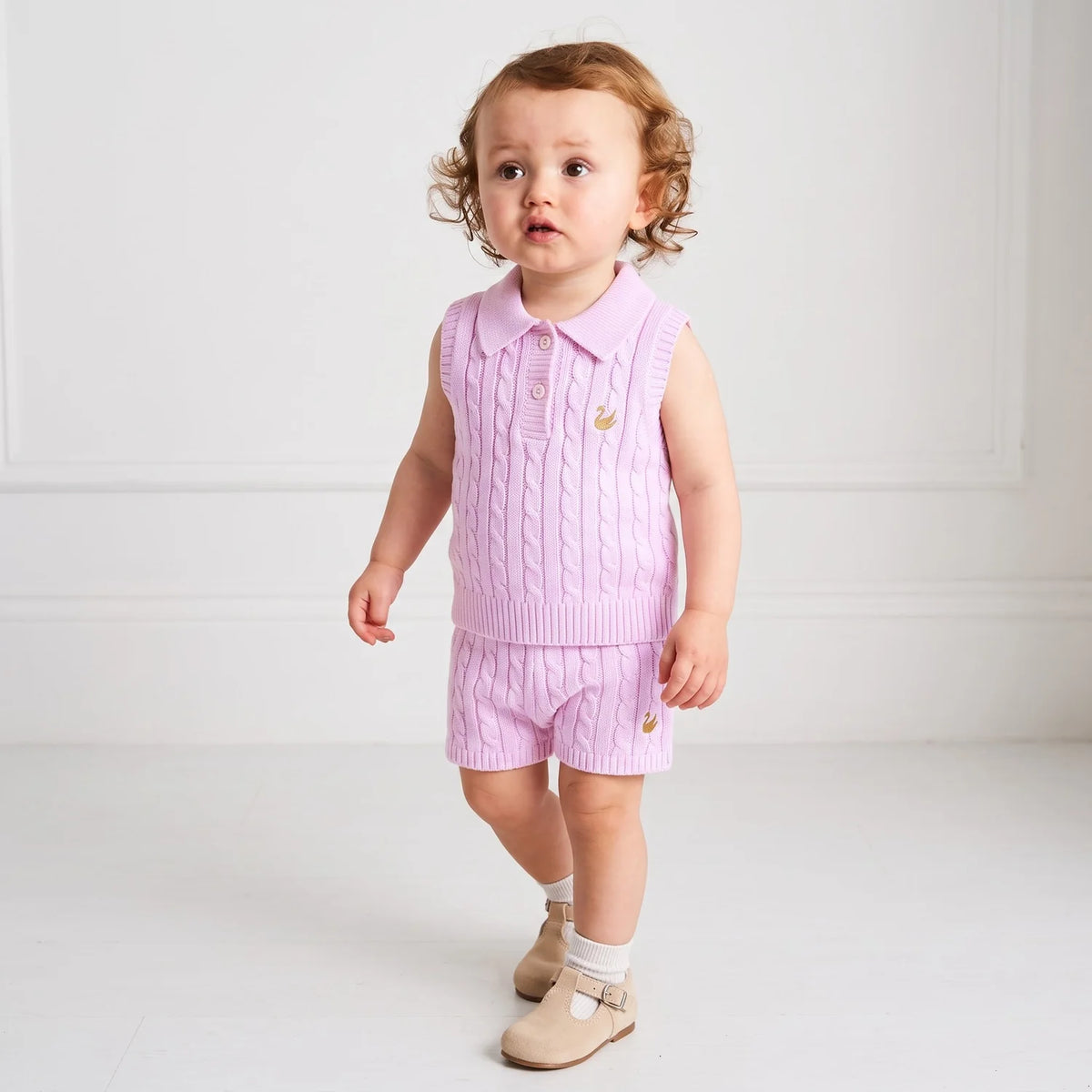 Lilac cable-knit shorts with elastic waist and ribbed leg hems, worn by toddler