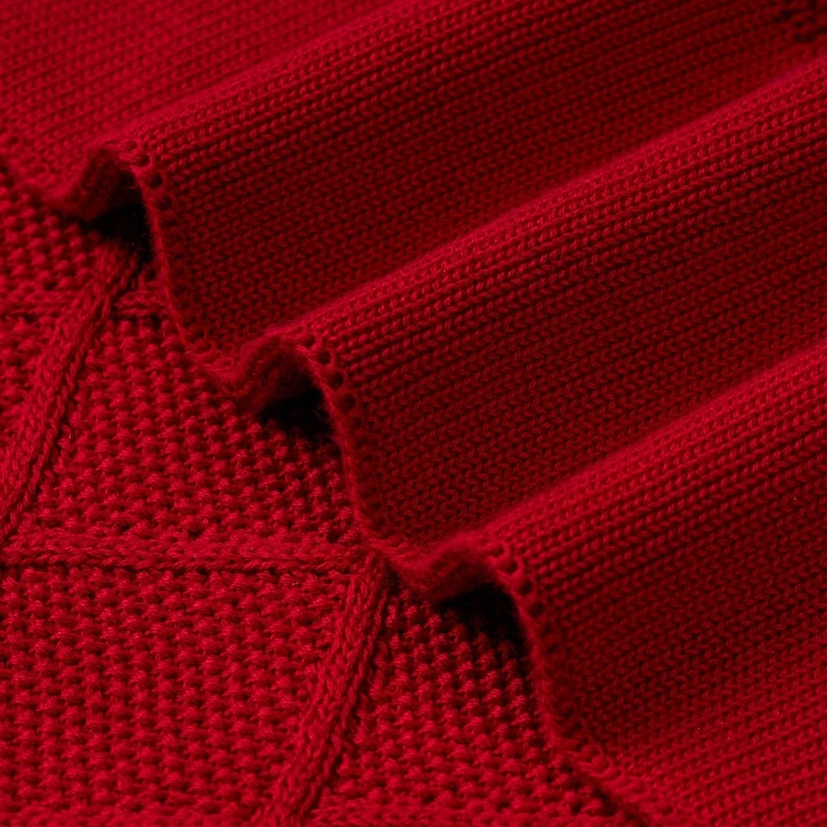 Red knit blanket edge with diamond-stitch texture and fringed knit trim