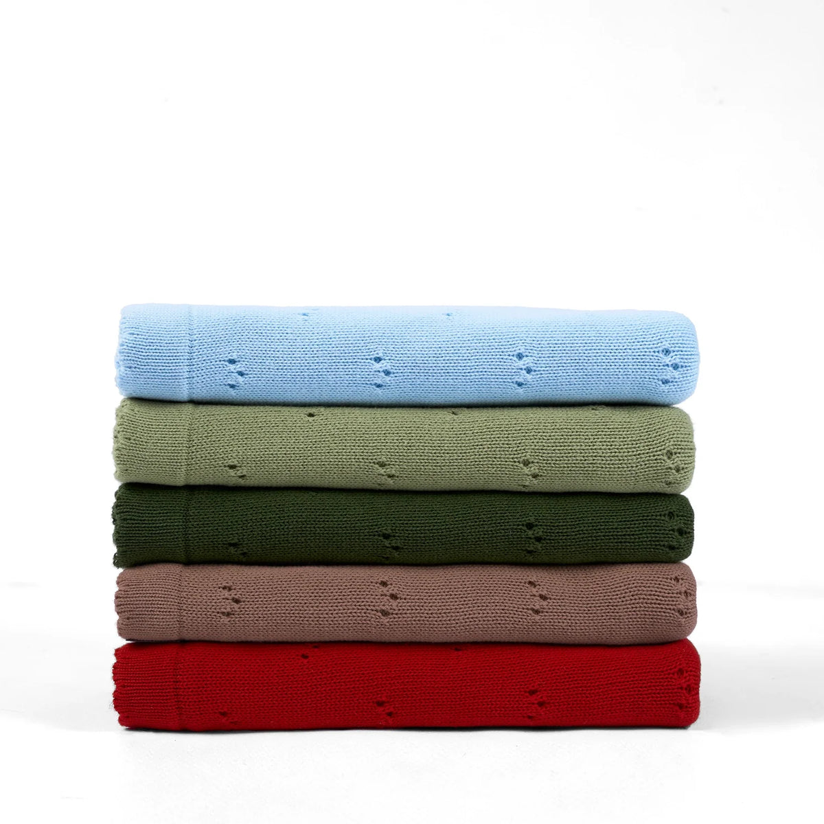 Pointelle baby knit blankets stacked in mocha, red, green, and blue folded layers