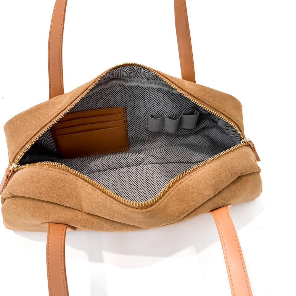 Camel suede barrel bag interior with chevron lining and zippered opening